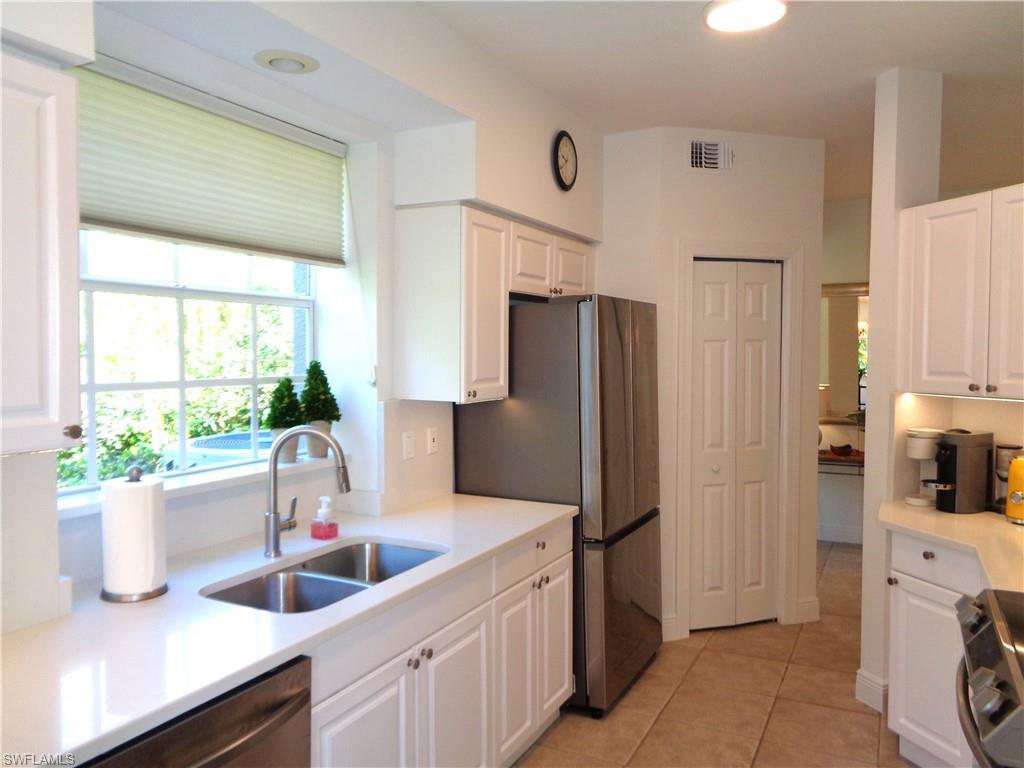 Kitchen featuring white cabinetry, plenty of natural light, stainless steel appliances, and light tile patterned floors