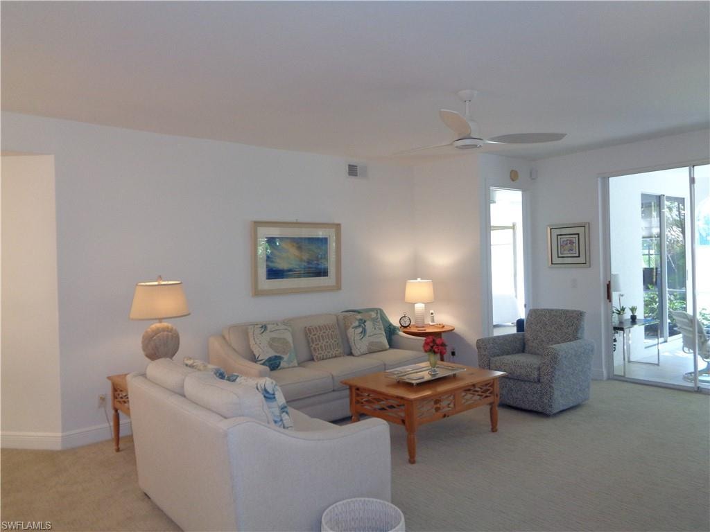 Living room featuring light colored carpet and ceiling fan