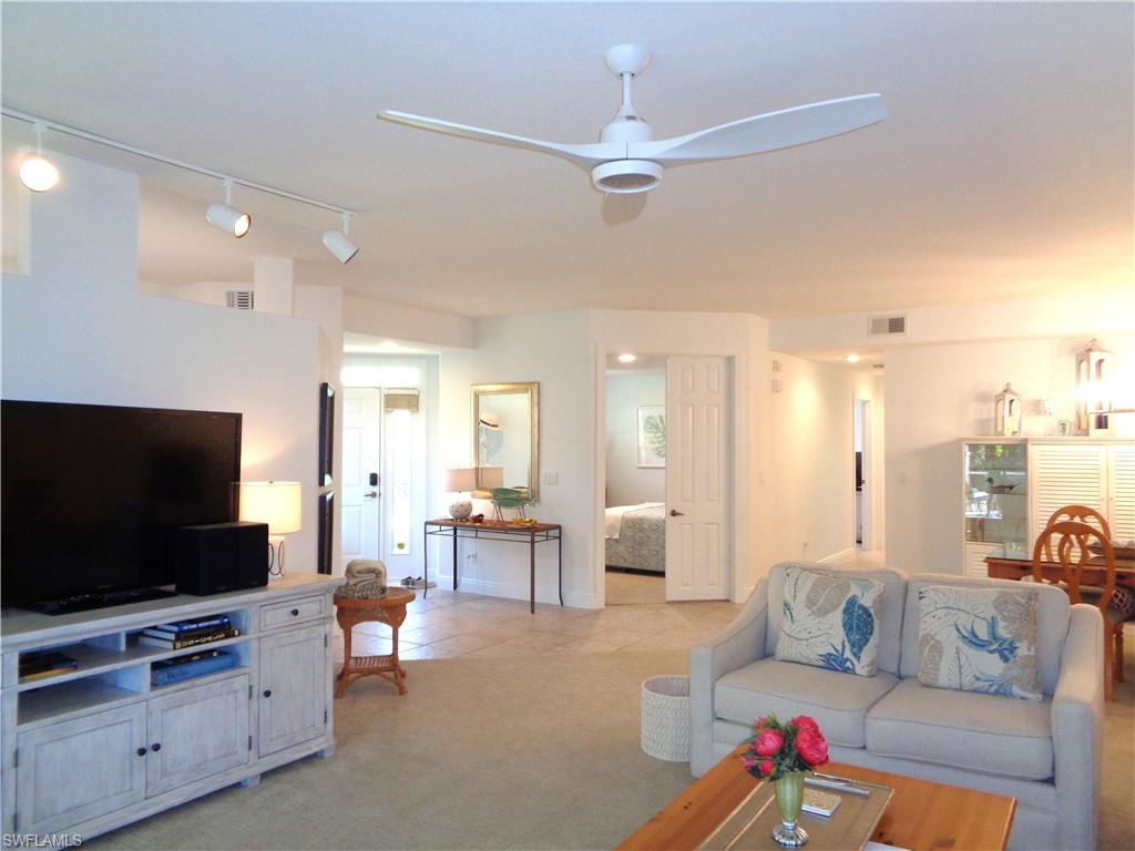 Living area featuring rail lighting, light carpet, and a ceiling fan