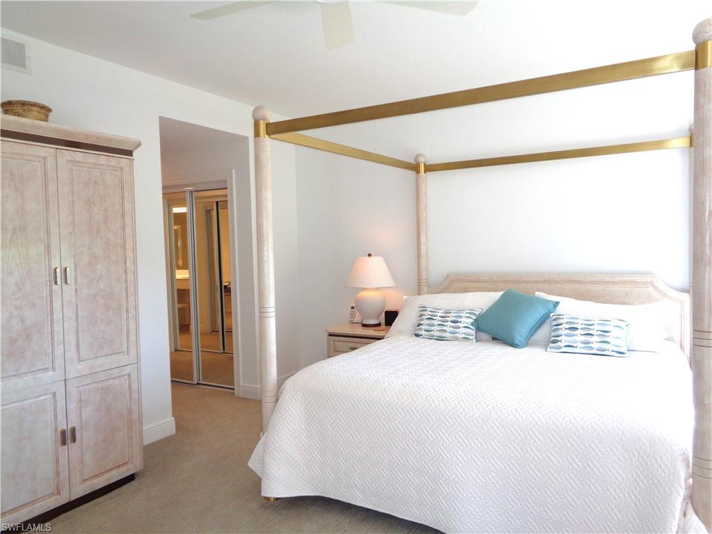 Bedroom with a closet, light carpet, and ceiling fan