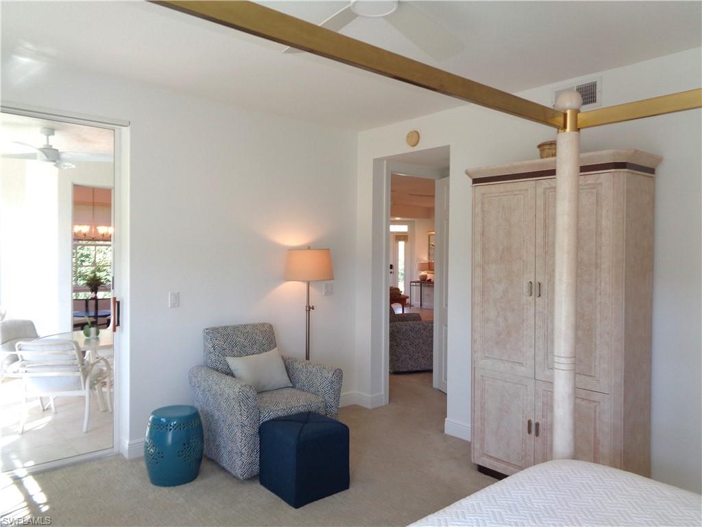 Bedroom featuring light carpet, a ceiling fan, and a chandelier