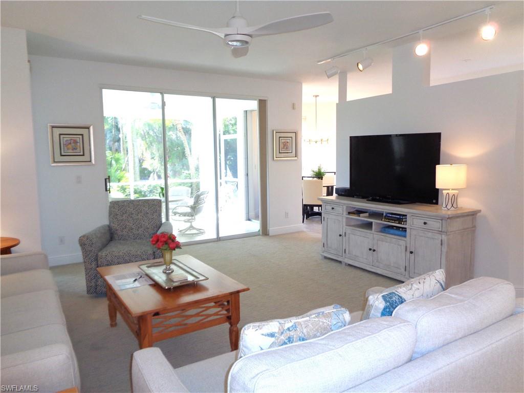 Living area with a ceiling fan, light carpet, and rail lighting