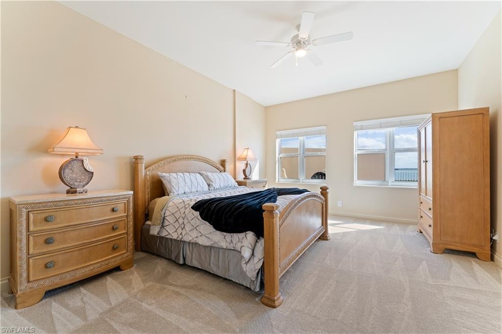 Bedroom with ceiling fan and light carpet