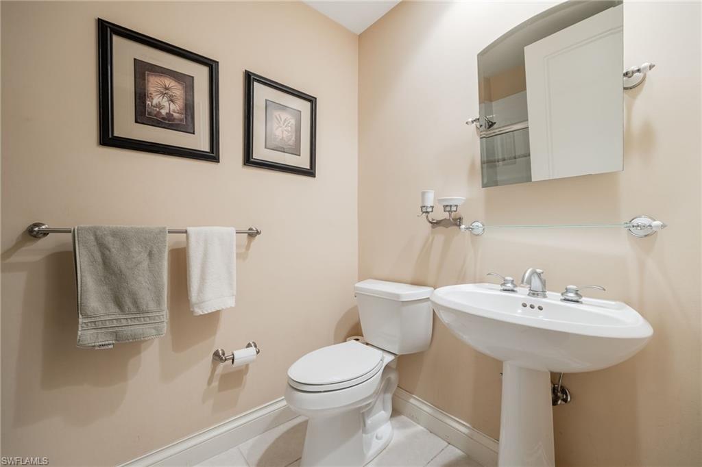 Bathroom with light tile patterned floors and a shower with shower door