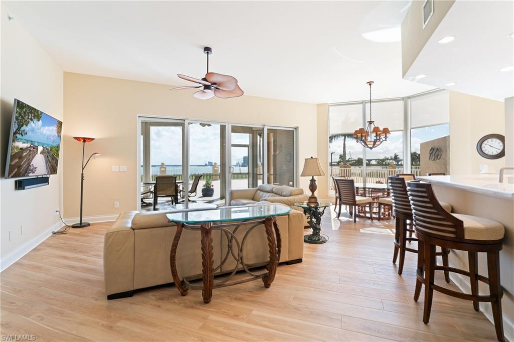 Living area featuring ceiling fan, light wood-style floors, and a chandelier