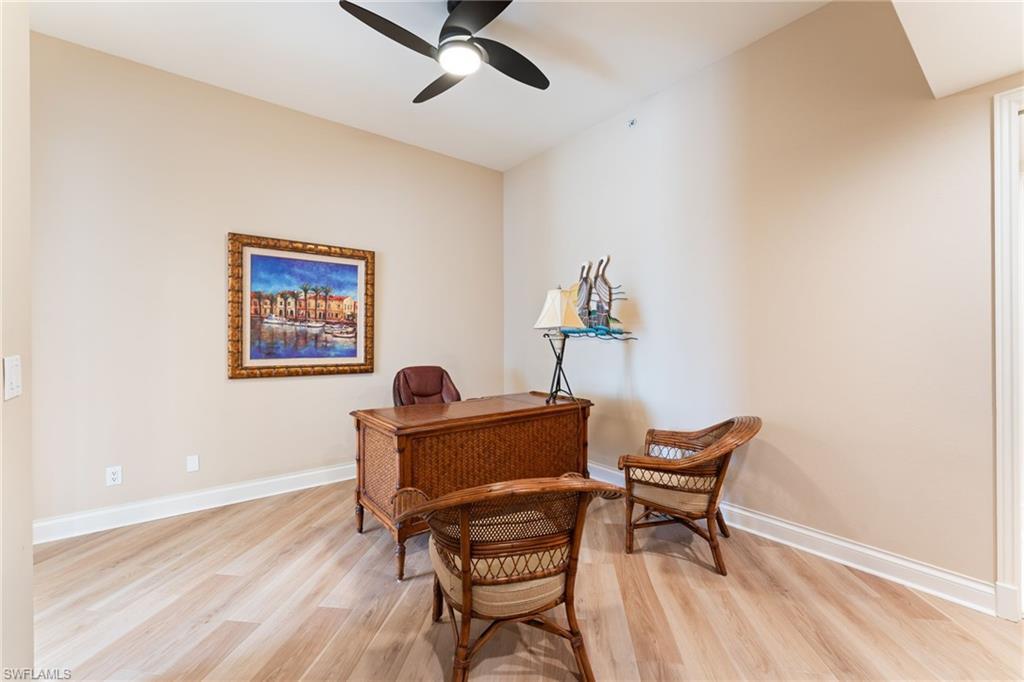 Office with light wood-type flooring and a ceiling fan