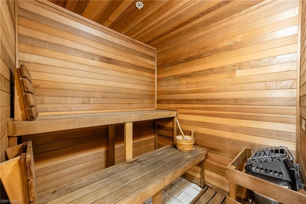Relaxing sauna with wood walls, wood ceiling, and tile patterned floors