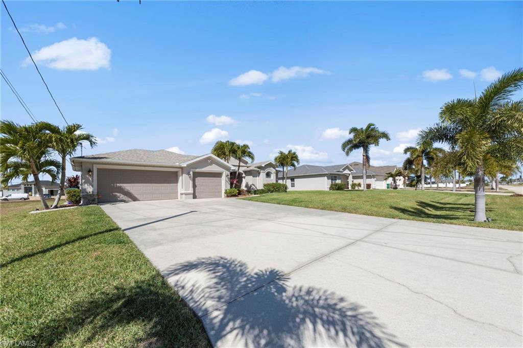 Single story home with a front lawn, an attached garage, concrete driveway, and a residential view