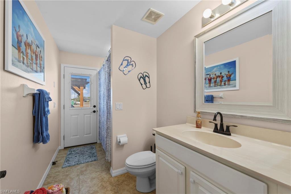 Bathroom with vanity, a shower with shower curtain, and light tile patterned floors