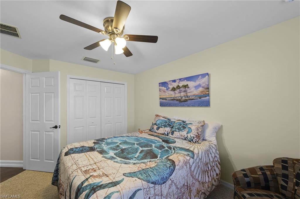 Bedroom featuring ceiling fan, a closet, and dark colored carpet