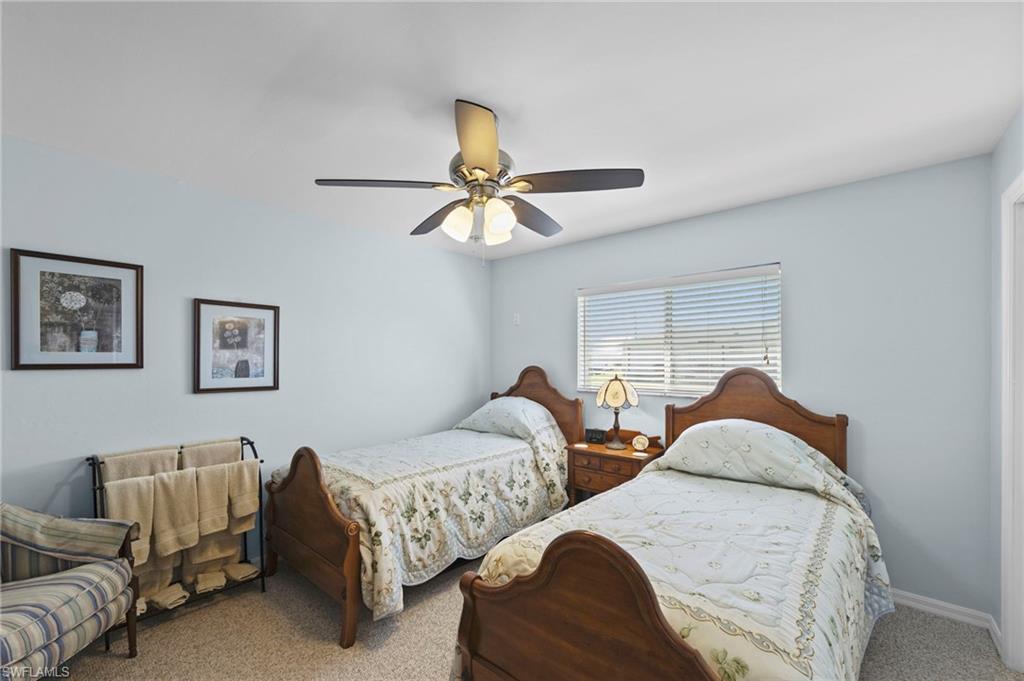 Carpeted bedroom with a ceiling fan
