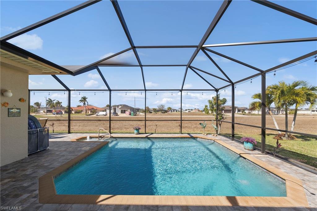 Outdoor pool featuring a sunroom, a lanai, a residential view, a lawn, and area for grilling