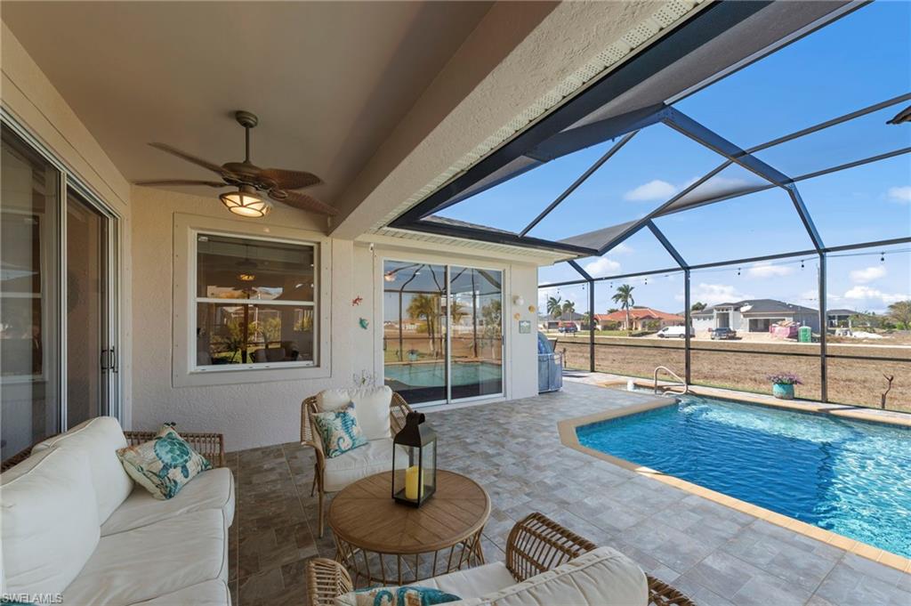 Swimming pool featuring a sunroom, a patio, a lanai, outdoor furniture, and a residential view