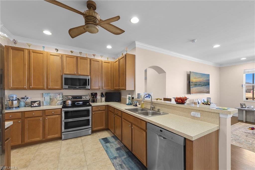 Kitchen featuring ornamental molding, stainless steel appliances, wood finish cabinetry, and recessed lighting