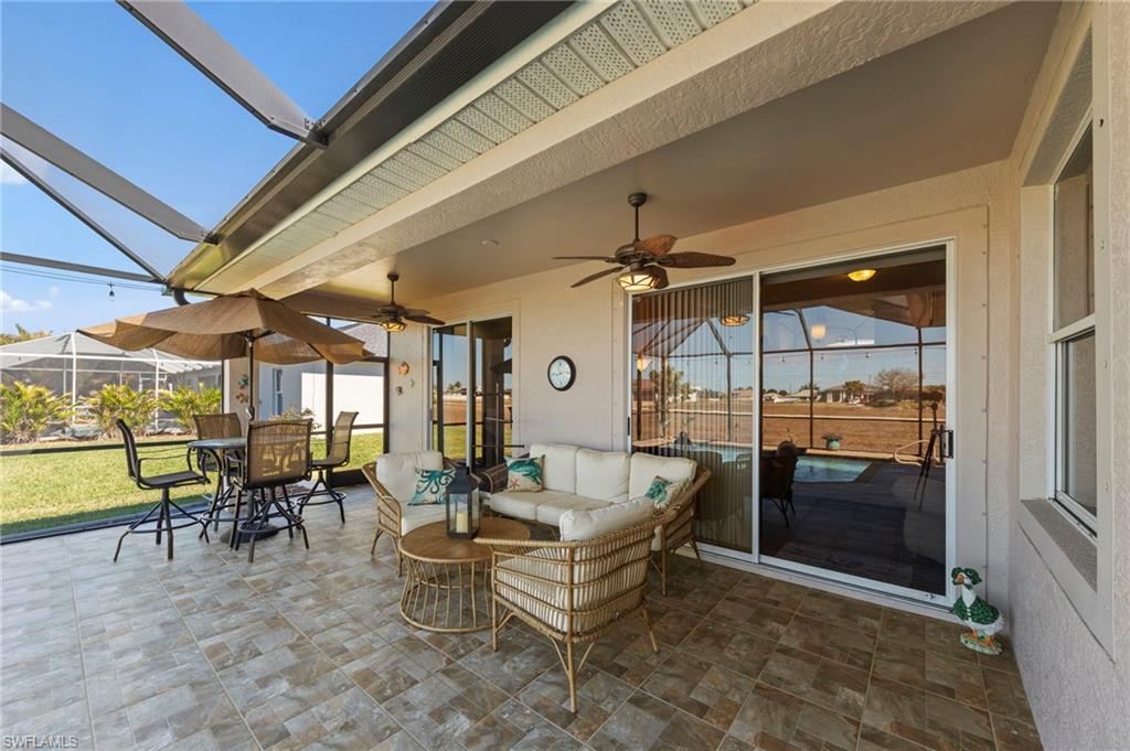 View of patio / terrace featuring a sunroom, outdoor lounge area, glass enclosure, and ceiling fan
