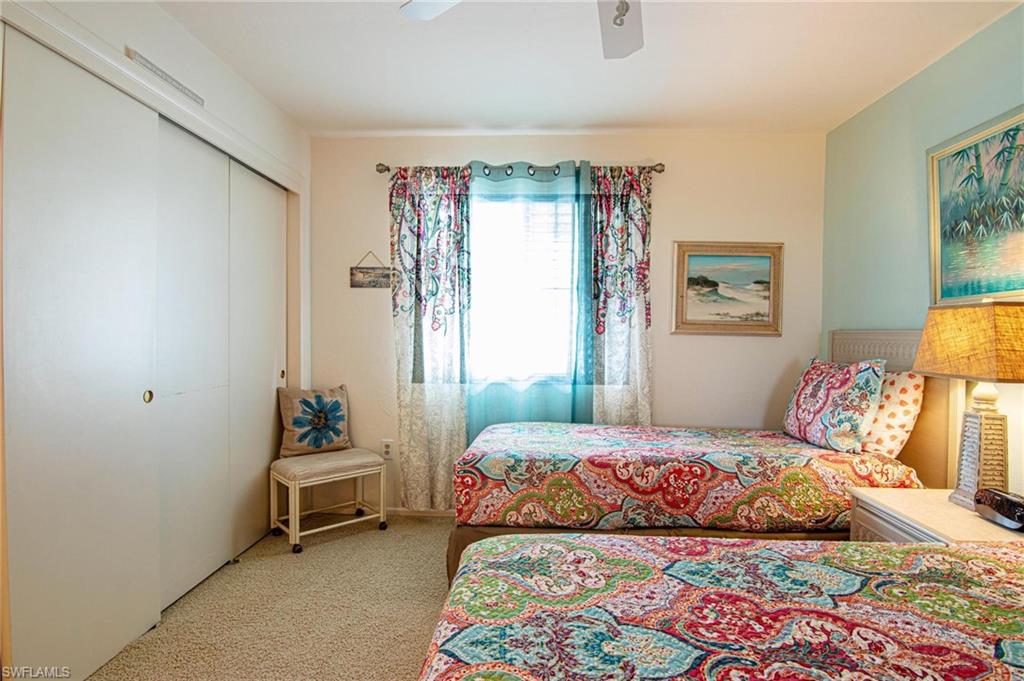 Bedroom featuring a closet, light carpet, and ceiling fan