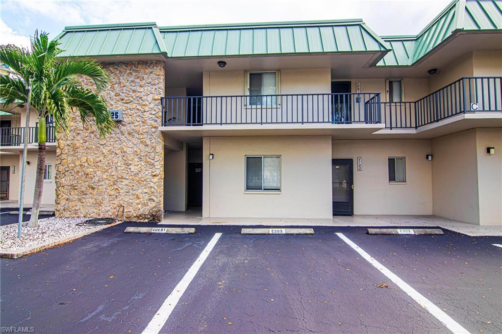 View of apartment building / complex with uncovered parking