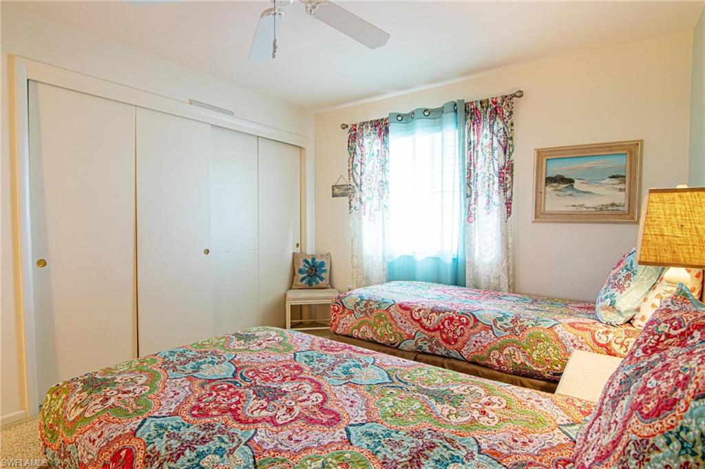 Bedroom featuring a ceiling fan, a closet, and light carpet
