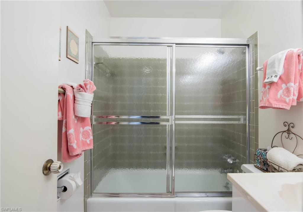 Bathroom featuring vanity and bath / shower combo with glass door