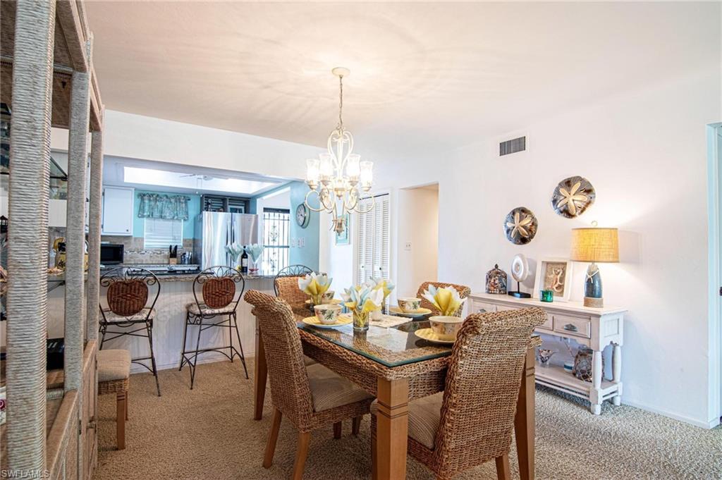 Dining area with light carpet and a chandelier