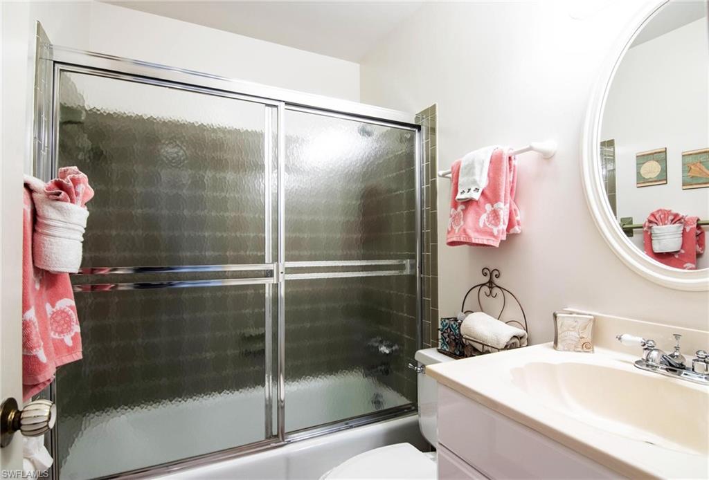 Full bath with vanity and bath / shower combo with glass door