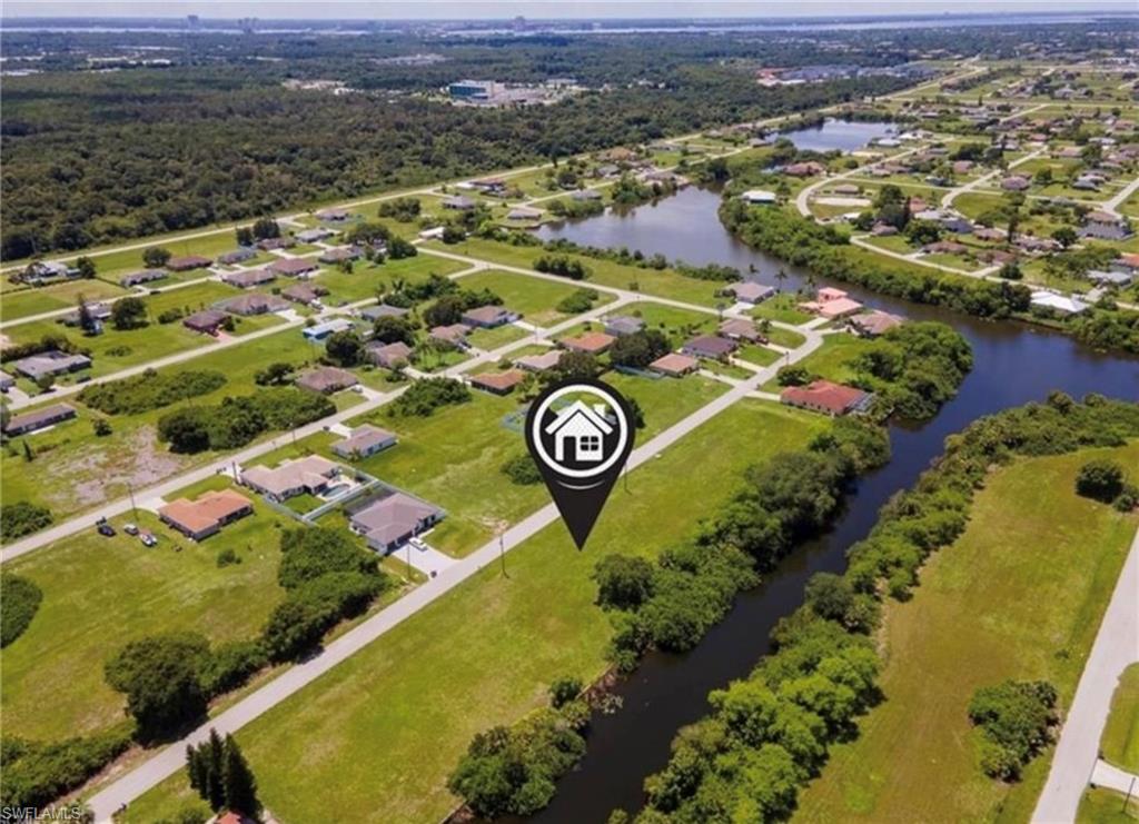Aerial overview of property's location featuring a nearby body of water and nearby suburban area