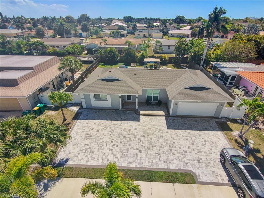 View of front of house with roof with shingles, an attached garage, decorative driveway, a residential view, and stucco siding