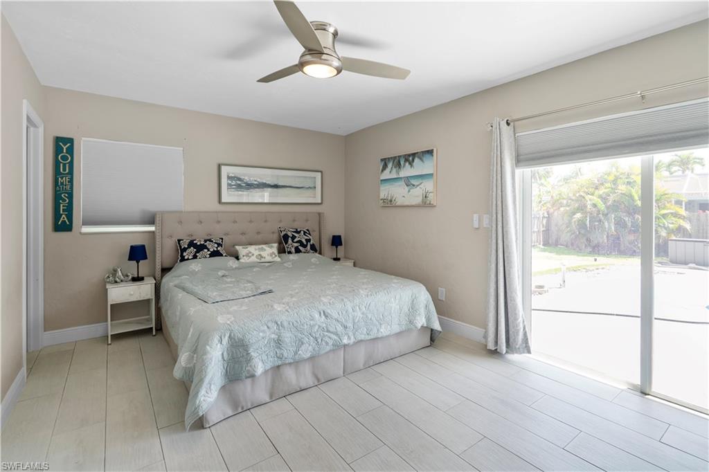 Bedroom featuring access to exterior, wood finish floors, and ceiling fan