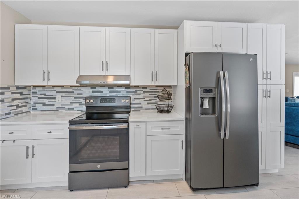 Kitchen featuring stainless steel appliances and white cabinetry
