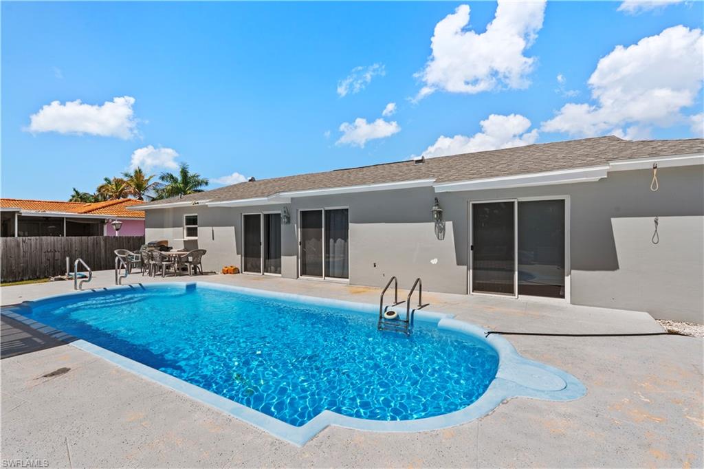 View of swimming pool featuring patio surround and outdoor dining area