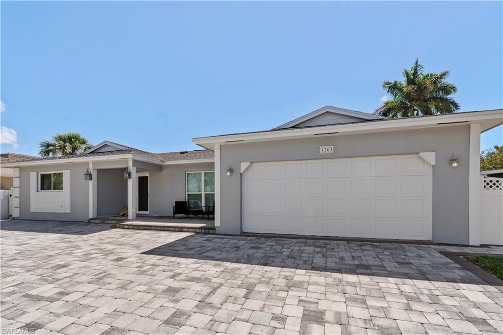 Single story home with stucco siding, decorative driveway, and an attached garage