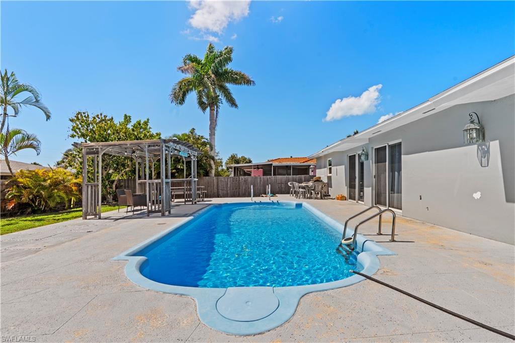 View of swimming pool with patio surround, a pergola, a fenced backyard, and outdoor dining space
