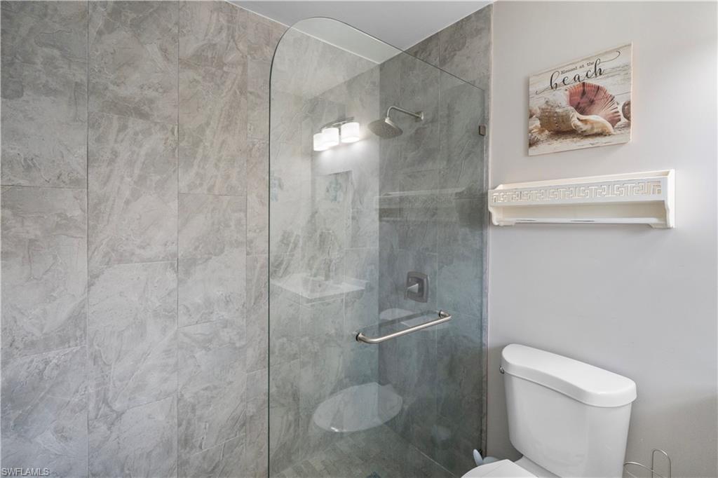 Full bathroom with toilet and a stall shower