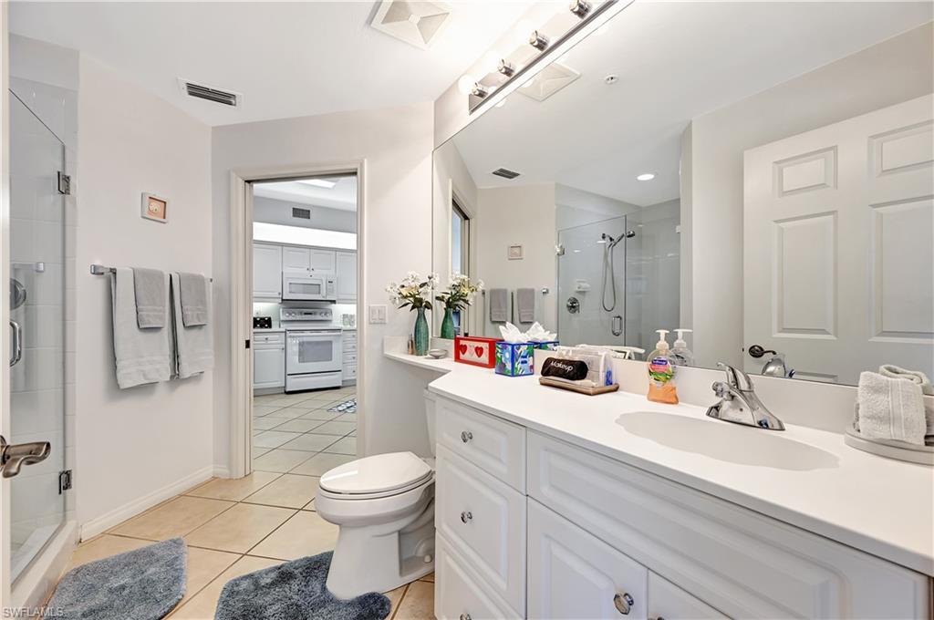 Bathroom with a stall shower, vanity, and light tile patterned floors