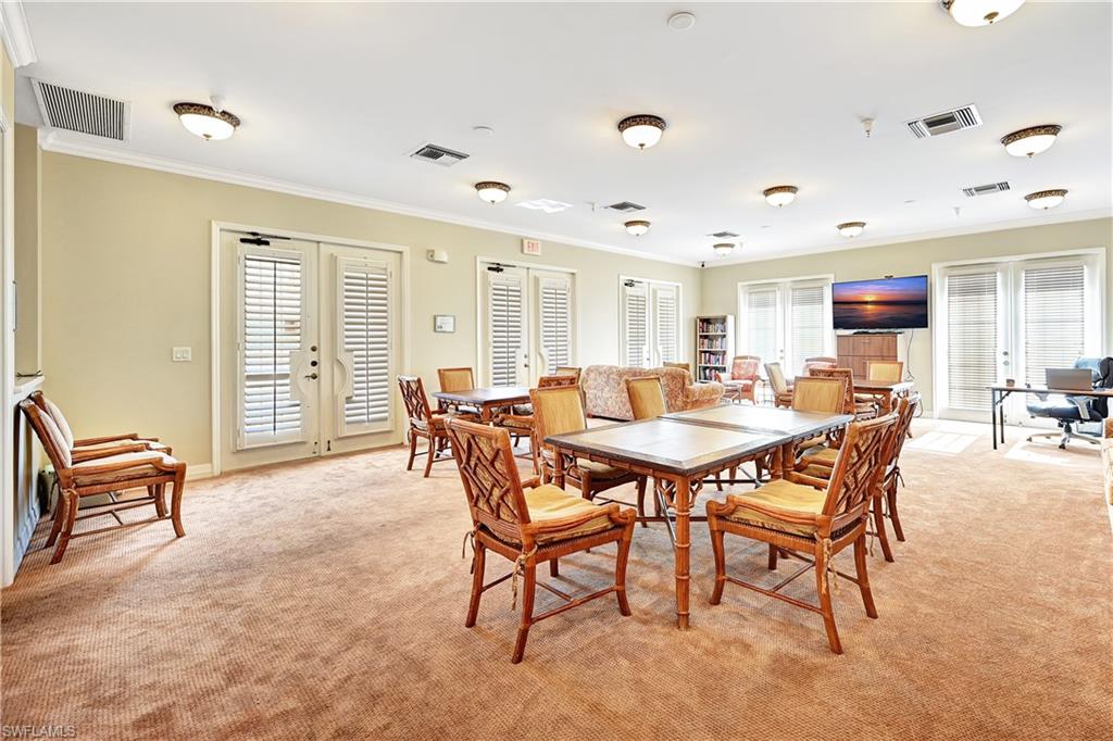 Dining area featuring french doors, crown molding, and light carpet
