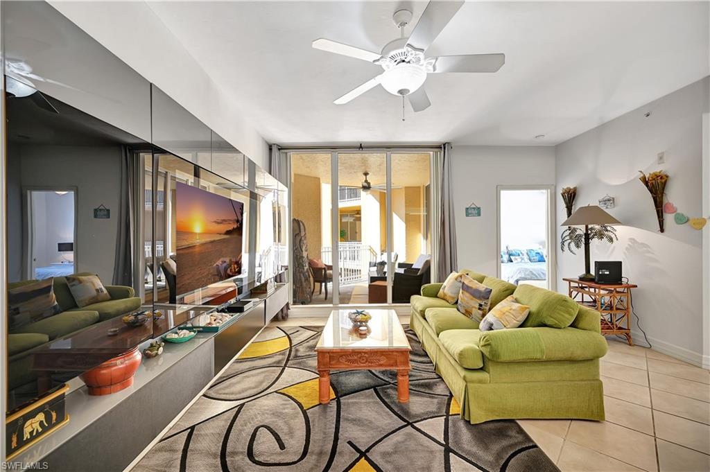 Tiled living area with a ceiling fan, expansive windows, and plenty of natural light