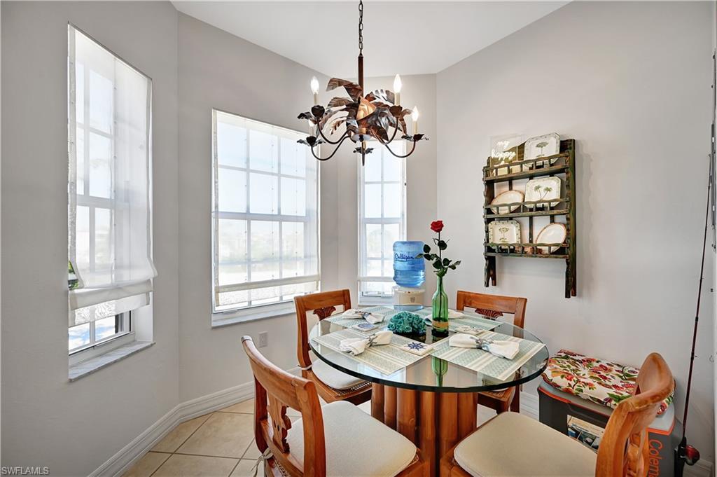 Dining space with light tile patterned floors and hanging lights