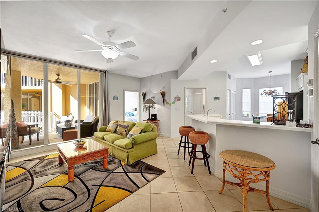 Living room with light tile patterned floors and a ceiling fan