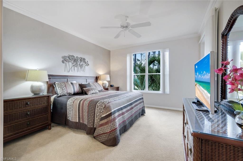 Bedroom featuring ornamental molding, light colored carpet, and a ceiling fan