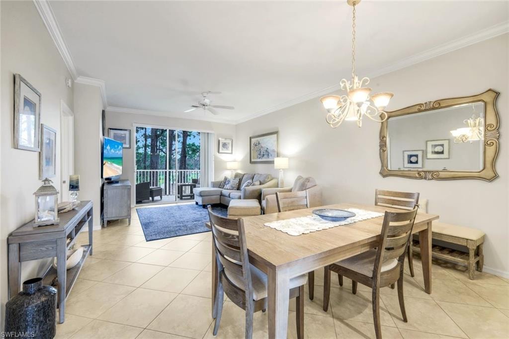 Dining space with ceiling fan, light tile patterned floors, a chandelier, and crown molding