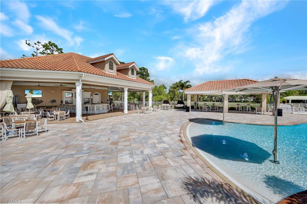 Community pool with a patio and an outdoor bar and dining area