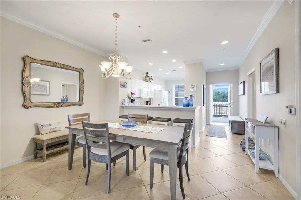 Dining area featuring crown molding, suspended lighting, and light tile patterned floors