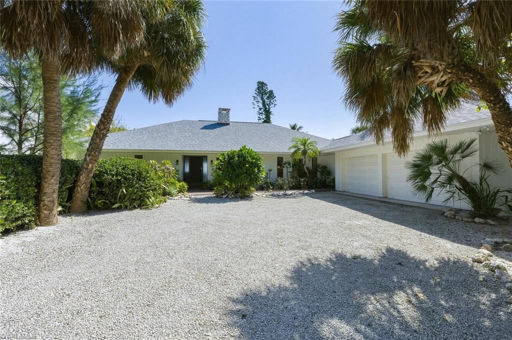Single story home with gravel driveway, a side load garage, and a shingled roof