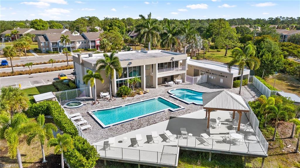 Community pool featuring a patio, a gazebo, view of scattered trees, a community hot tub, and a deck