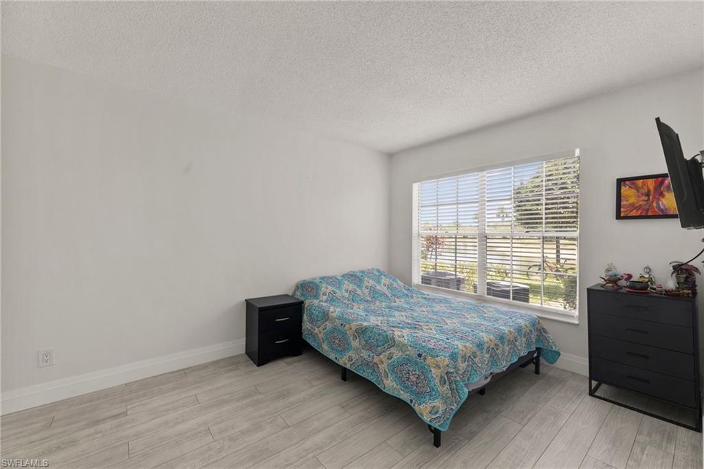 Bedroom with a textured ceiling and light wood finished floors