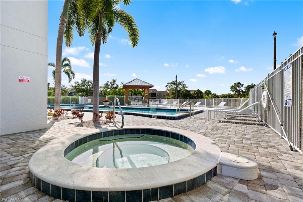 Community pool with a gazebo, a patio area, and a hot tub