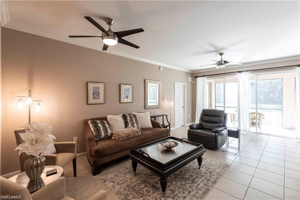 Living area with crown molding, ceiling fan, and tile patterned floors