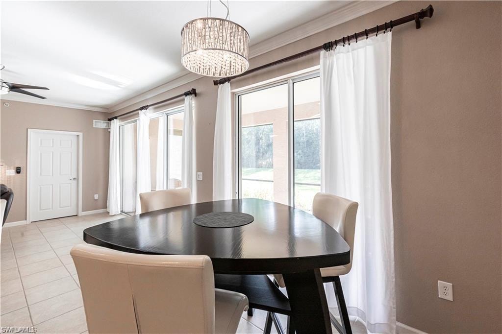 Dining space featuring light tile patterned floors, ornamental molding, and a ceiling fan