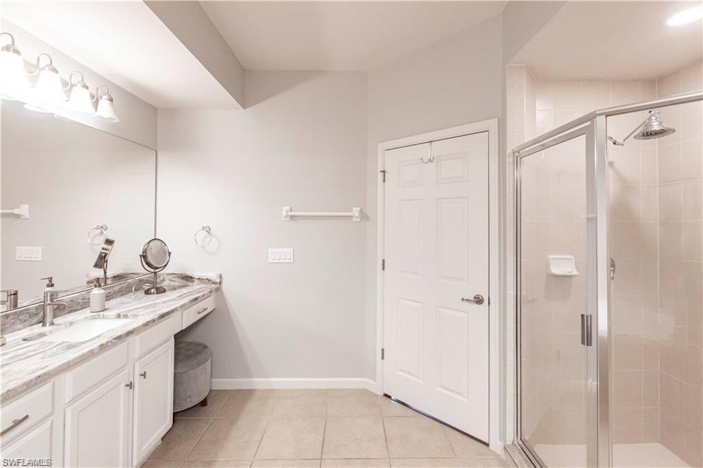 Bathroom with vanity, a shower stall, and light tile patterned floors