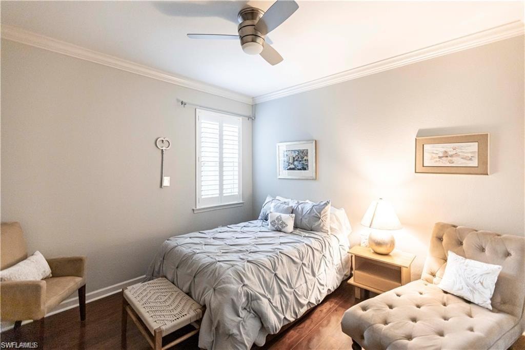Bedroom with crown molding, wood finished floors, and a ceiling fan